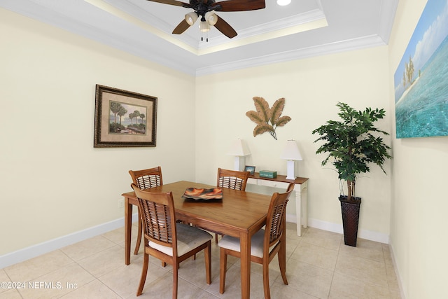 dining area with light tile patterned floors, crown molding, a raised ceiling, and ceiling fan