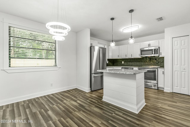 kitchen featuring decorative light fixtures, white cabinetry, decorative backsplash, a center island, and stainless steel appliances