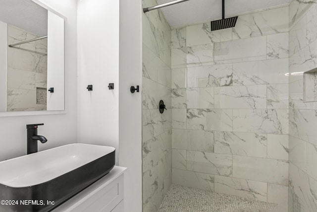 bathroom with a tile shower and sink