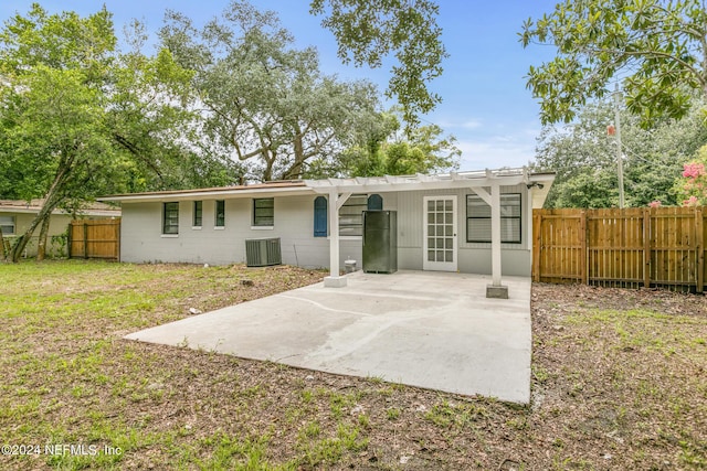 rear view of property featuring a yard, central AC, and a patio area