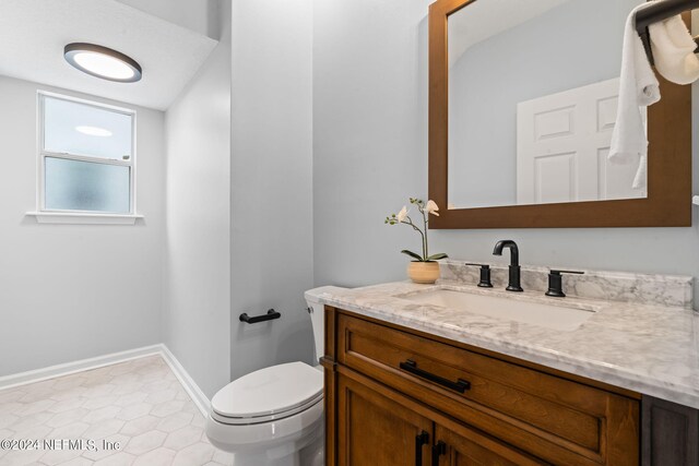 bathroom featuring vanity, toilet, and tile patterned floors