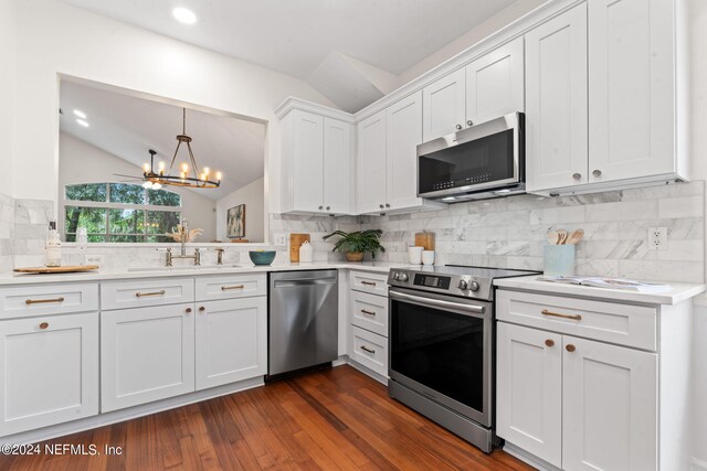 kitchen featuring backsplash, lofted ceiling, dark hardwood / wood-style floors, and stainless steel appliances