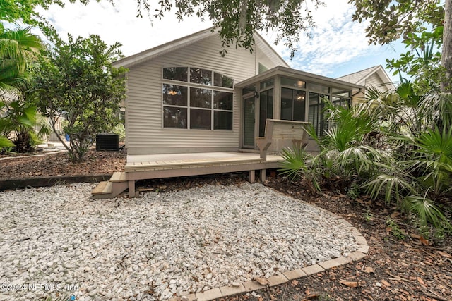 back of house featuring central AC, a sunroom, and a deck