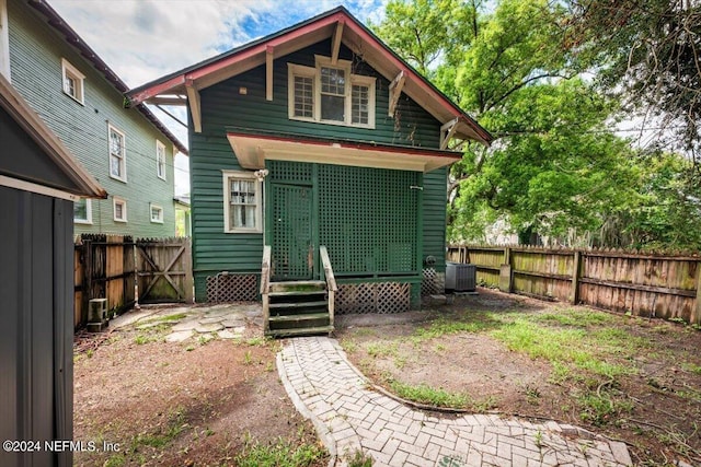 back of house with central AC and a fenced backyard