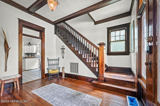 foyer with visible vents, beamed ceiling, baseboards, and hardwood / wood-style flooring