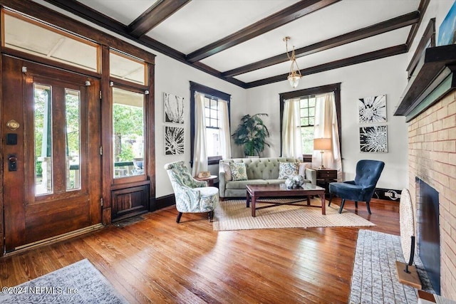 interior space with beamed ceiling, a fireplace, and hardwood / wood-style flooring