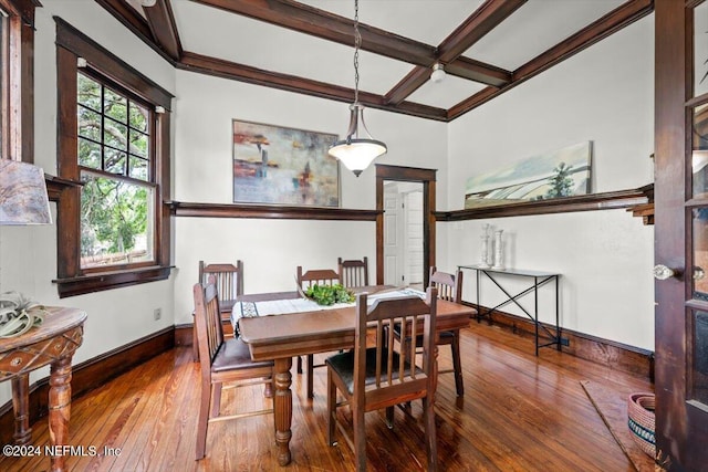 dining space featuring coffered ceiling, wood-type flooring, beam ceiling, and baseboards