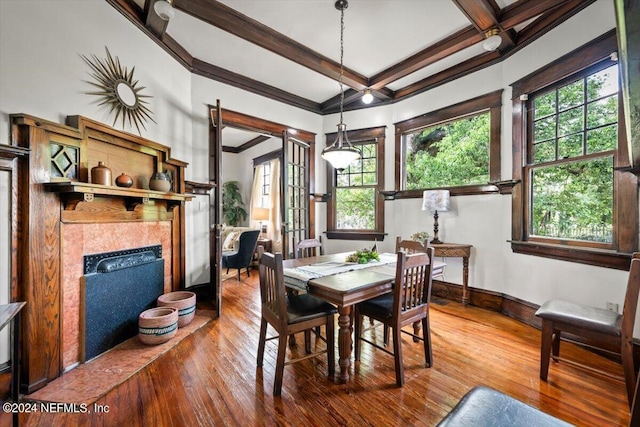 dining room with ornamental molding, hardwood / wood-style floors, a fireplace, and a healthy amount of sunlight