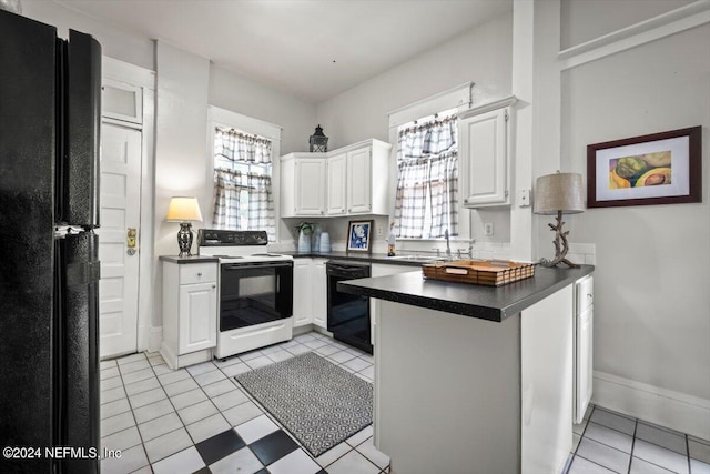 kitchen with a peninsula, a sink, white cabinetry, black appliances, and dark countertops