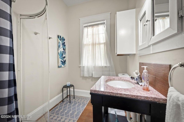 full bath featuring a shower with curtain, wood finished floors, vanity, and baseboards