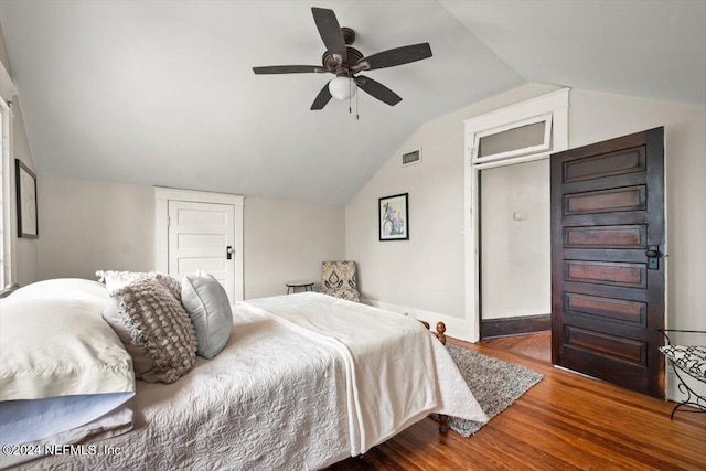 bedroom with visible vents, ceiling fan, vaulted ceiling, wood finished floors, and baseboards