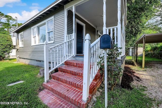 doorway to property featuring a carport and a lawn