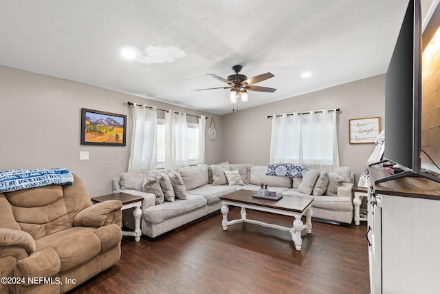 living room with a textured ceiling, dark hardwood / wood-style floors, and ceiling fan