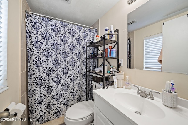 bathroom featuring vanity, toilet, curtained shower, and a textured ceiling