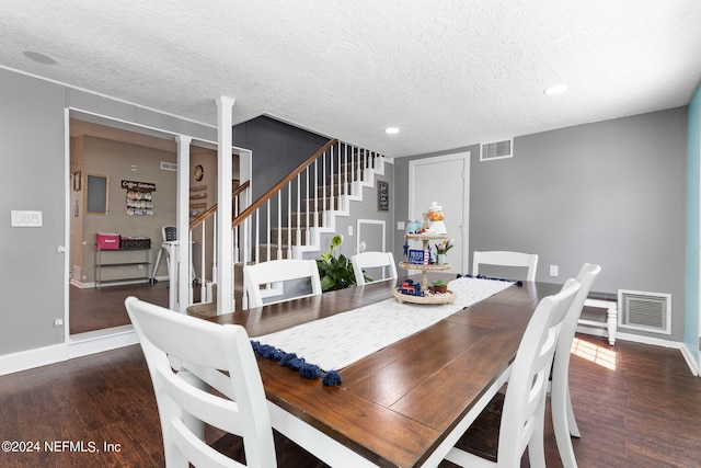 dining space featuring dark hardwood / wood-style flooring and a textured ceiling