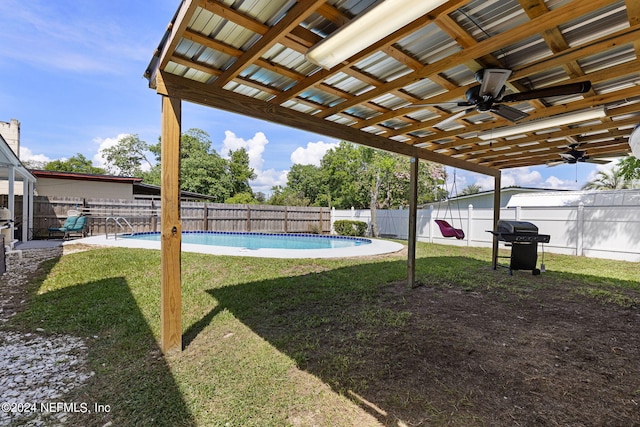 view of yard featuring ceiling fan and a fenced in pool