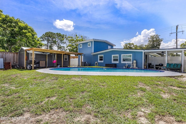 back of house with a fenced in pool, a yard, a storage unit, and central AC