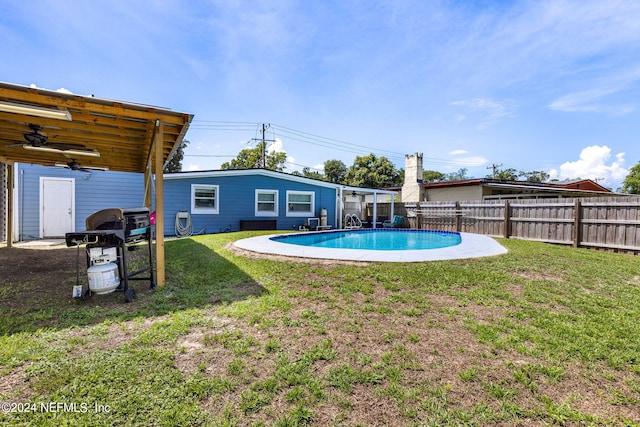 view of yard with ceiling fan and a fenced in pool