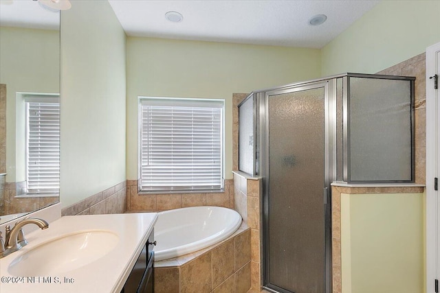 bathroom with vanity and separate shower and tub