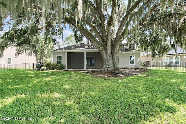 rear view of property featuring a lawn