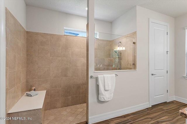 bathroom featuring a textured ceiling and a tile shower