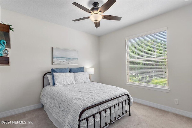 bedroom featuring ceiling fan and light carpet