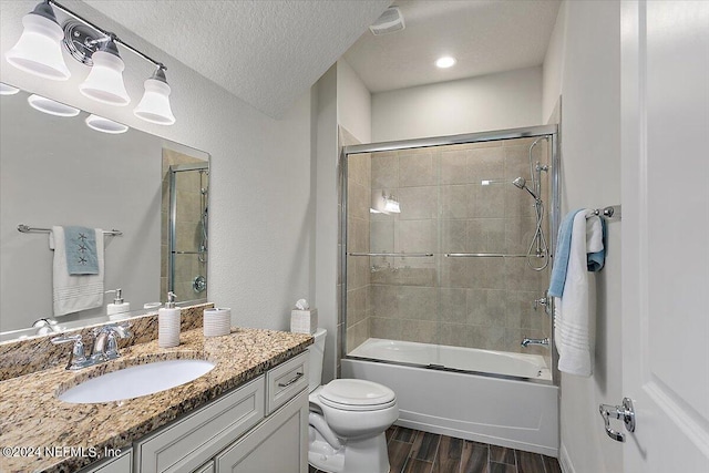 full bathroom with toilet, vanity, shower / bath combination with glass door, and a textured ceiling