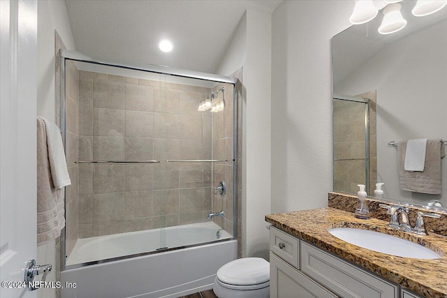 full bathroom with toilet, bath / shower combo with glass door, and vanity