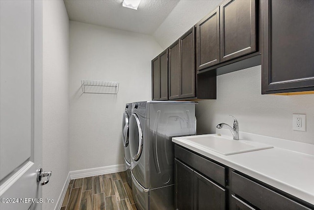 washroom with independent washer and dryer, sink, and cabinets