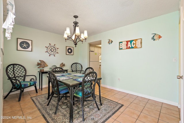 tiled dining space with an inviting chandelier and a textured ceiling