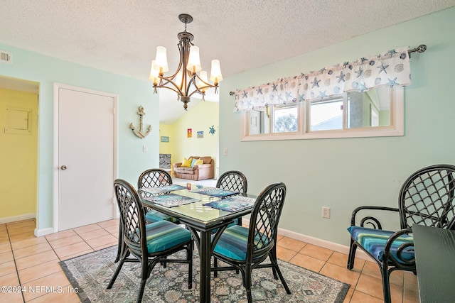 tiled dining area with a textured ceiling, lofted ceiling, and a chandelier