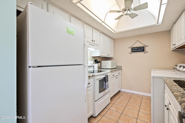 kitchen featuring white appliances, washing machine and dryer, white cabinetry, ceiling fan, and light tile patterned floors