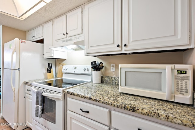 kitchen featuring white appliances, light stone counters, white cabinets, under cabinet range hood, and a textured ceiling