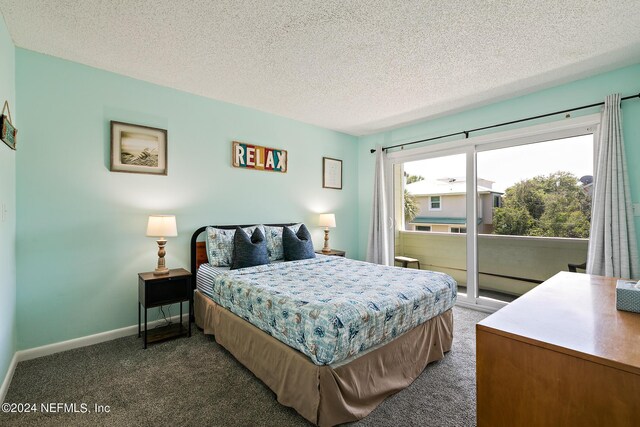 bedroom featuring dark carpet, a textured ceiling, and multiple windows