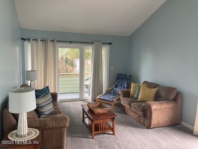 living area with vaulted ceiling and carpet