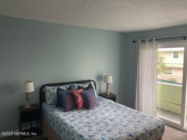 bedroom featuring carpet flooring and a textured ceiling