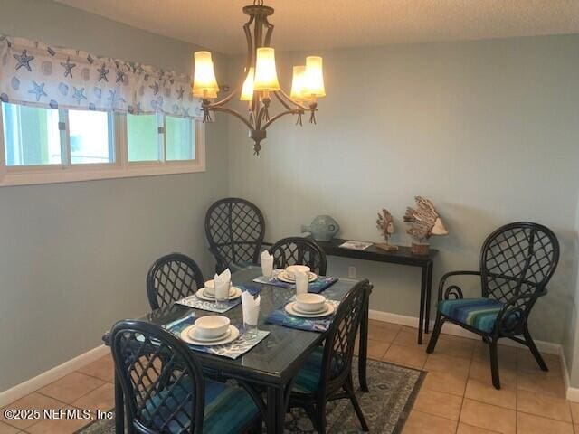 dining space featuring baseboards, a notable chandelier, and light tile patterned flooring