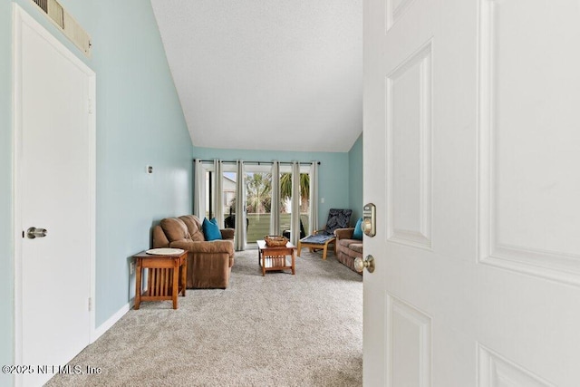 carpeted living area with vaulted ceiling