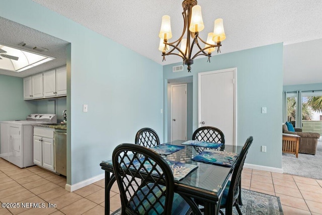 dining space featuring visible vents, light tile patterned floors, baseboards, a chandelier, and a textured ceiling