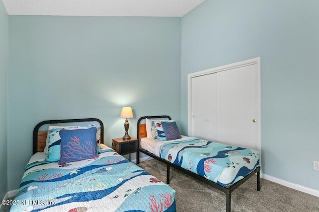 bedroom featuring baseboards, carpet floors, and a closet