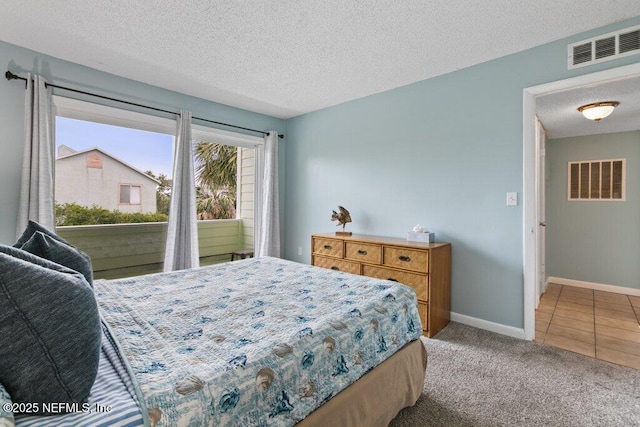 carpeted bedroom featuring baseboards, a textured ceiling, and visible vents
