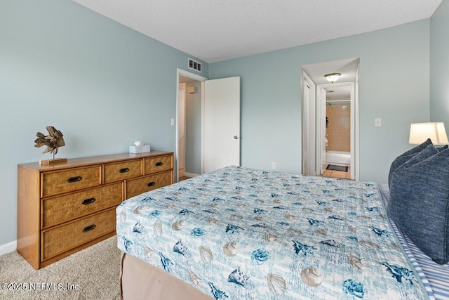 bedroom with baseboards, ensuite bath, visible vents, and carpet flooring
