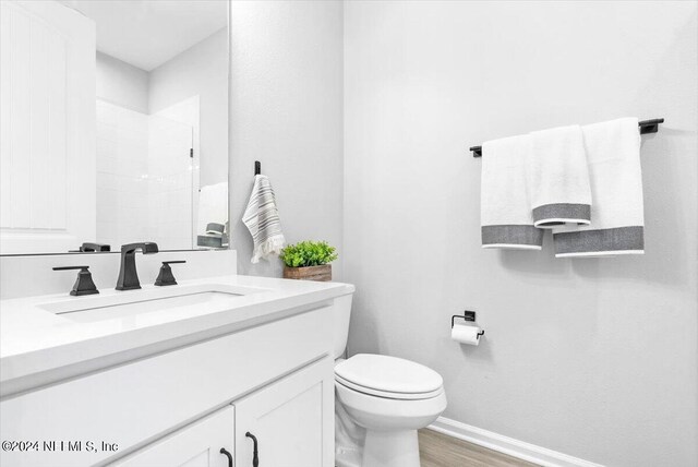 bathroom with hardwood / wood-style flooring, toilet, and vanity