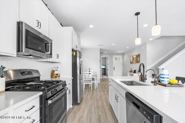 kitchen featuring white cabinets, light wood-type flooring, and stainless steel appliances