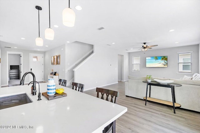 dining room with light hardwood / wood-style flooring, sink, and ceiling fan