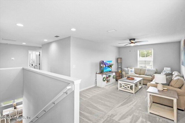 carpeted living room with ceiling fan