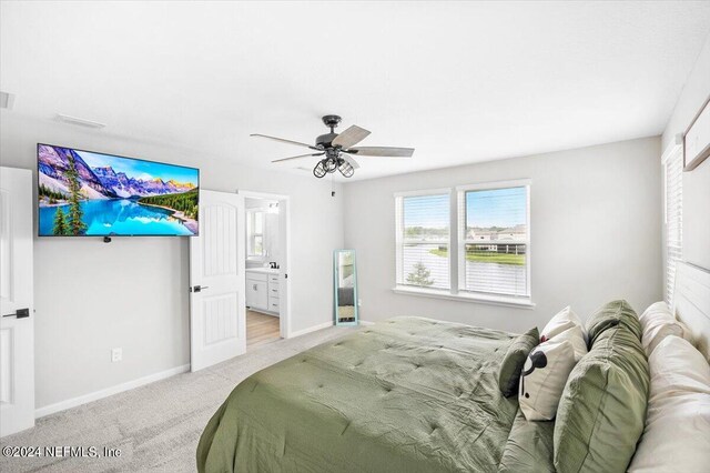 carpeted bedroom featuring ensuite bathroom and ceiling fan