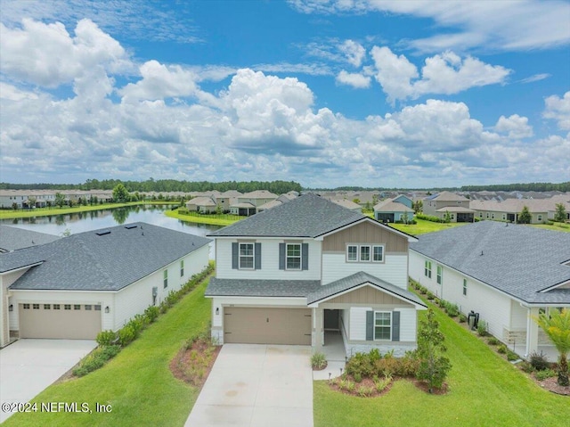 view of front of home featuring a garage, a water view, and a front lawn