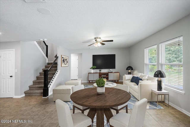 tiled dining room featuring ceiling fan and a textured ceiling