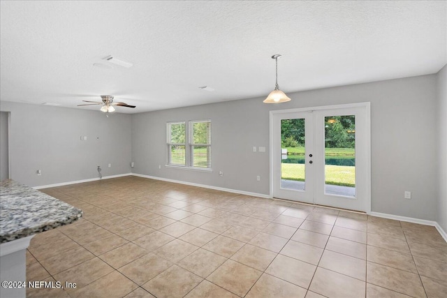 unfurnished living room featuring a wealth of natural light, french doors, and light tile patterned flooring